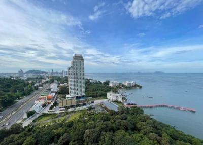 Panoramic aerial view of a coastal area with high-rise buildings, lush greenery, and expansive water views