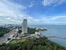 Panoramic aerial view of a coastal area with high-rise buildings, lush greenery, and expansive water views