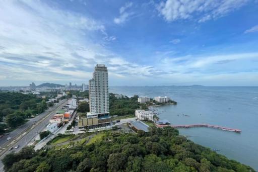 Panoramic aerial view of a coastal area with high-rise buildings, lush greenery, and expansive water views