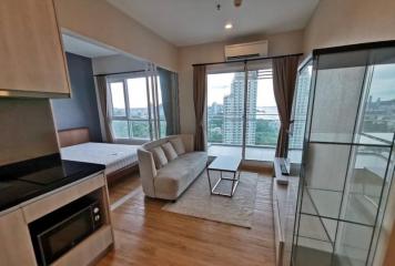 Modern living room with open kitchenette and city view