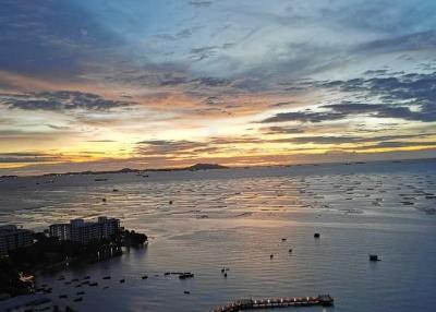 Panoramic view of the ocean during sunset with city skyline and pier