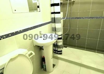 Compact bathroom with modern amenities and tiled walls