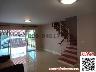 Spacious living area with a staircase leading to the upper floor and sliding glass doors to a balcony