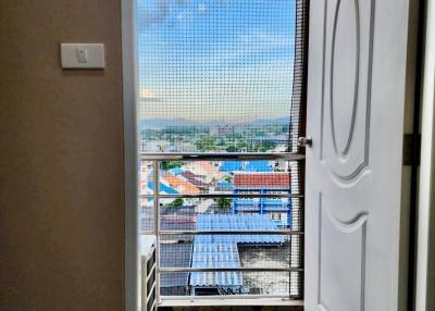 Open balcony door leading to an outdoor view with protective net