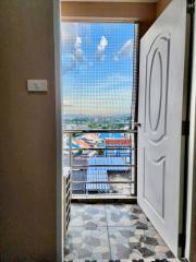 Open balcony door leading to an outdoor view with protective net