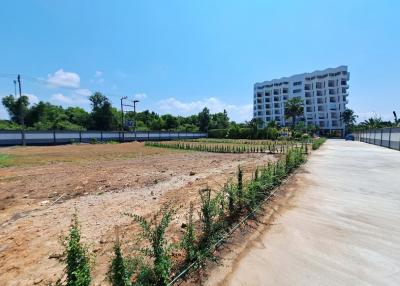 Open land area in front of a residential building with clear skies