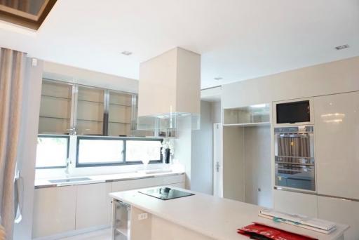 Modern white kitchen with stainless steel appliances and ample natural light