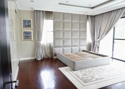 Spacious bedroom with elegant hardwood flooring and large windows