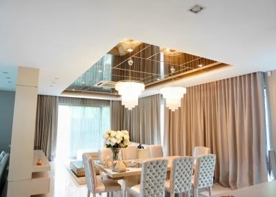 Elegant dining room with modern chandeliers and large mirror ceiling