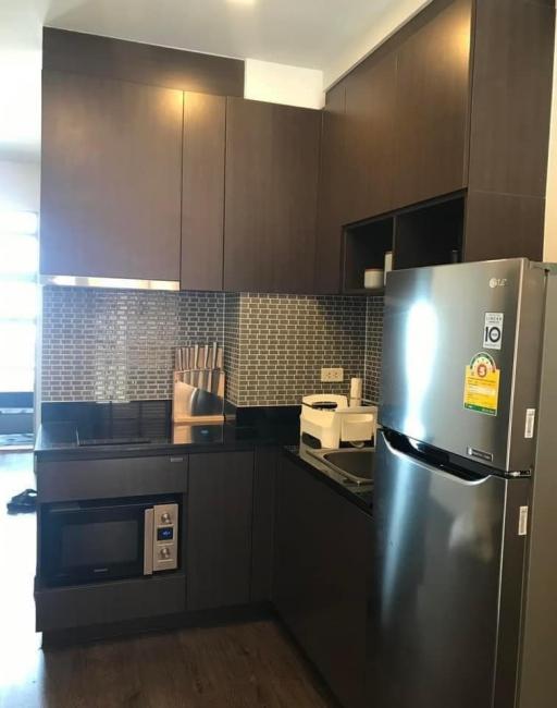 Modern kitchen with stainless steel appliances and dark wood cabinetry