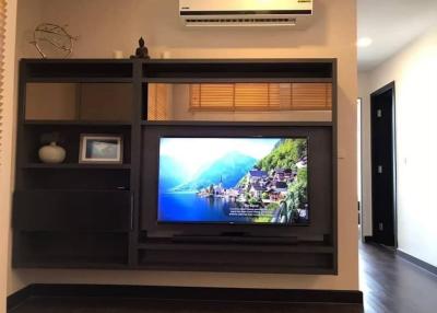 Modern living room interior with wall-mounted TV and shelving units