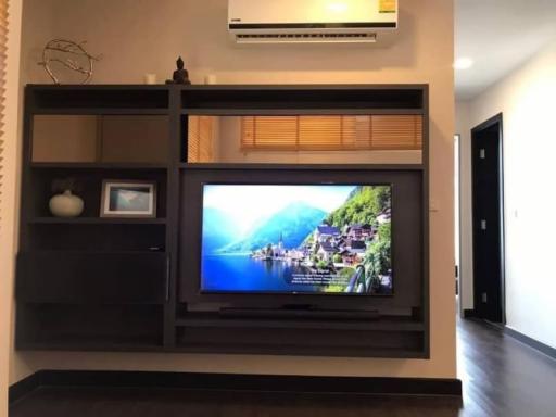 Modern living room interior with wall-mounted TV and shelving units