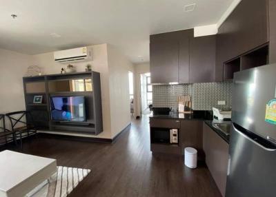 Modern open concept living room and kitchen area with wooden flooring