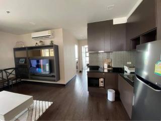 Modern open concept living room and kitchen area with wooden flooring