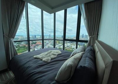 Modern bedroom with panoramic city view and ample natural light