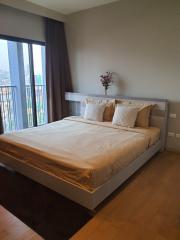 Modern bedroom with a large bed and city view from window