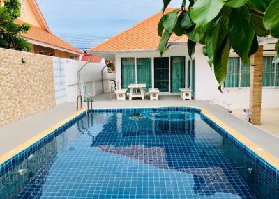 Swimming pool with blue tiles adjacent to a residential building