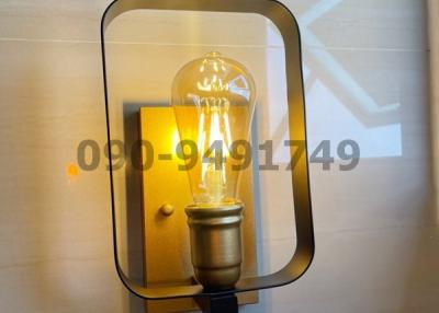 Modern wall-mounted light fixture with visible filament bulb