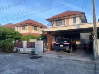 Two-story residential house with a carport and red tile roof