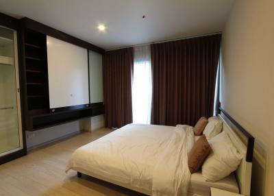 Modern bedroom with large window and built-in wardrobe