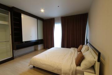 Modern bedroom with large window and built-in wardrobe