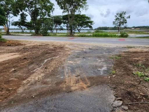 Underdeveloped land adjacent to paved road with natural scenery in the background