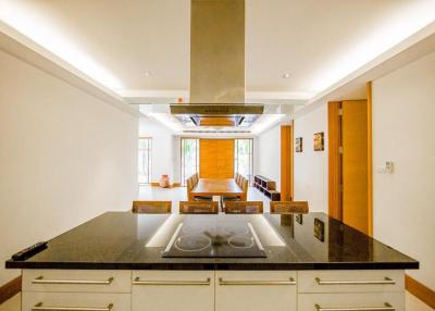 Modern kitchen with granite countertops leading to a bright living area