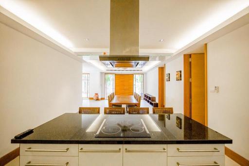 Modern kitchen with granite countertops leading to a bright living area