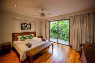 Spacious bedroom with large windows and lush greenery view