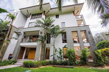 Modern multi-story residential building with lush greenery