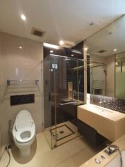 Modern bathroom with glass shower enclosure and mosaic tile details