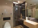 Modern bathroom with glass shower enclosure and mosaic tile details