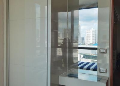 Partial view of a modern room with reflective wardrobe and seating area