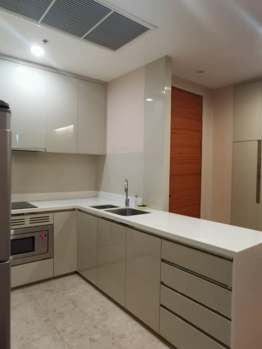 Modern kitchen with built-in appliances and wooden door