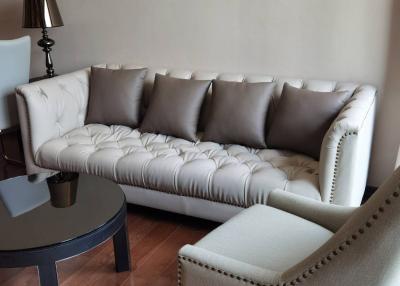 Elegant living room with a tufted sofa, round coffee table, and a classic lamp