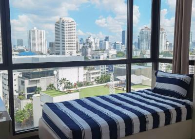 Modern bedroom with large windows and city view