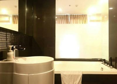 Modern bathroom interior with a bathtub and dark tiles