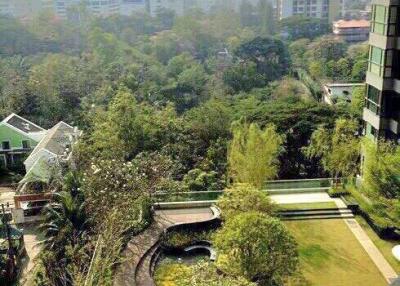 Cityscape view from a high-rise showing surrounding greenery and residential buildings