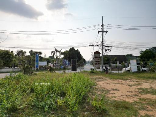Empty plot of land with utility poles and wires against a clear sky