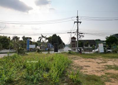Empty plot of land with utility poles and wires against a clear sky