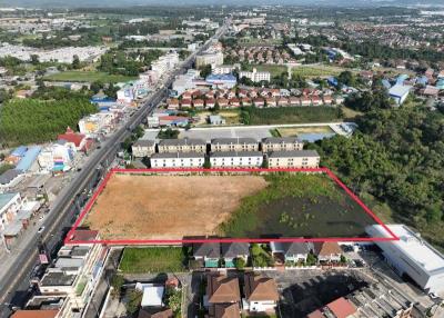 Aerial view of land parcel for sale with adjacent housing and urban environment
