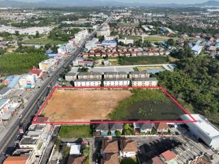 Aerial view of land parcel for sale with adjacent housing and urban environment