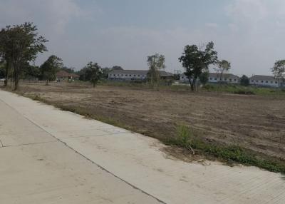 Suburban development area with empty plots and new housing in the background