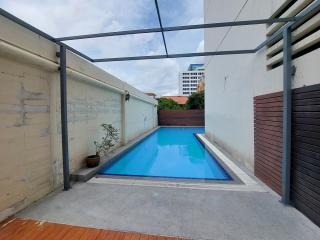 Private backyard with swimming pool, decking, and urban view