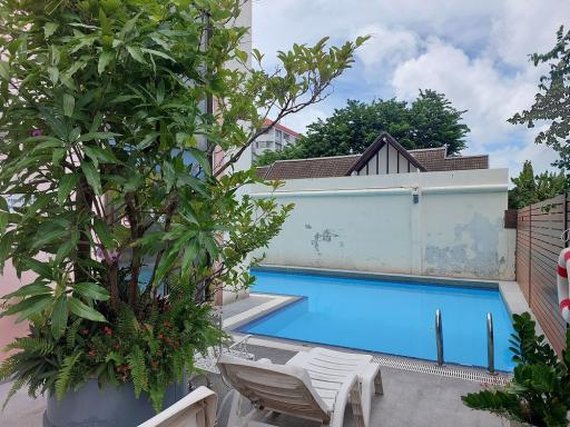 Private swimming pool with sun loungers and greenery in a residential property