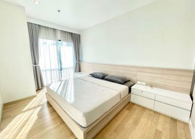 Bright and modern bedroom with large bed and hardwood floor