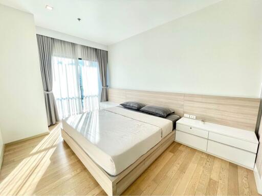 Bright and modern bedroom with large bed and hardwood floor