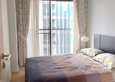 Cozy bedroom with wooden flooring and balcony access