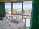 Bright bedroom with large windows and city view