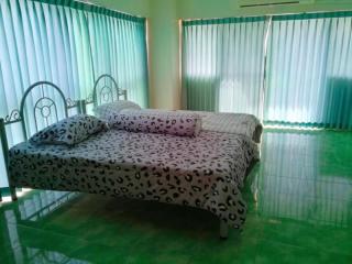 Spacious bedroom with large bed and green tiled flooring